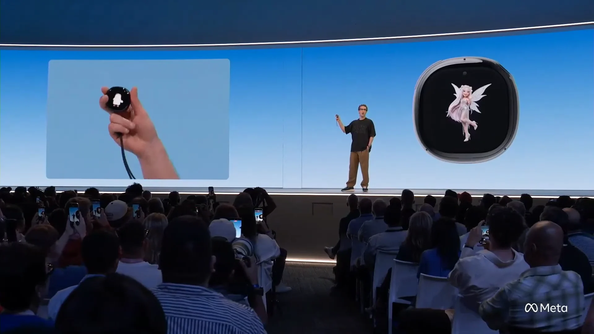 Zuckerberg holds Muse Charm at Connect, with its avatar enlarged on the stage screen.
